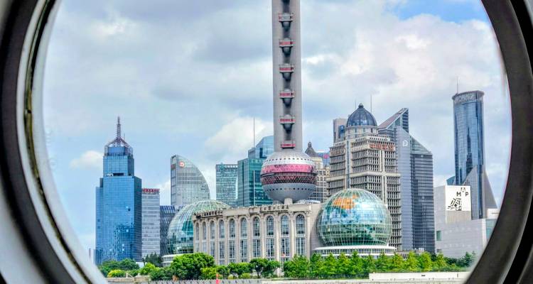 Skyline futuriste de Shanghai avec la Tour Orientale des Perles encadrée par une fenêtre circulaire ressemblant à un hublot.