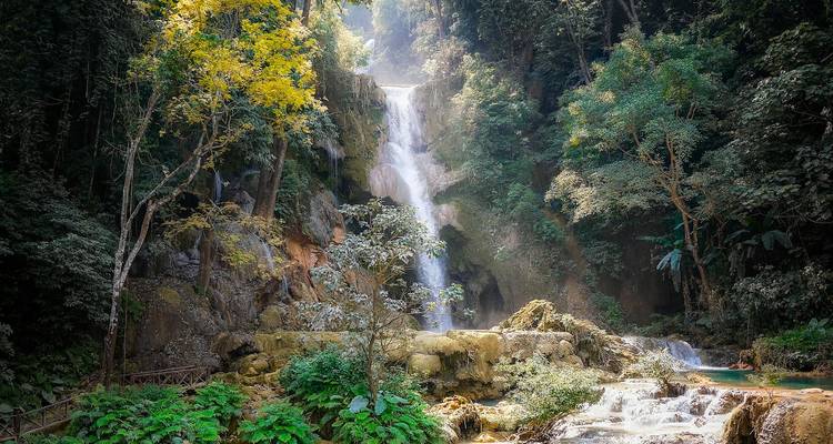 La cascade multi-étages de Kuang Si se déverse à travers la jungle dense dans des bassins turquoise entourés de verdure.