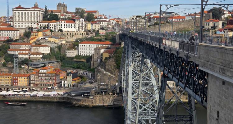 Vista panorámica del colorido frente fluvial de Oporto y el puente Dom Luís I que atraviesa el río Douro.