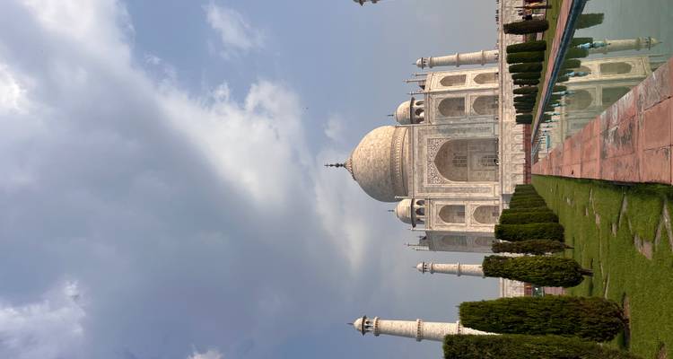 The Taj Mahal rises majestically above symmetrical gardens and a reflecting pool.