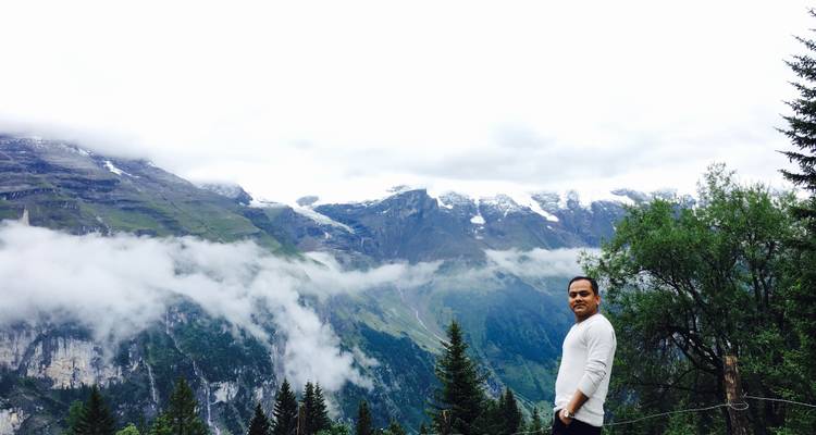 Personne posant avec un arrière-plan montagneux.