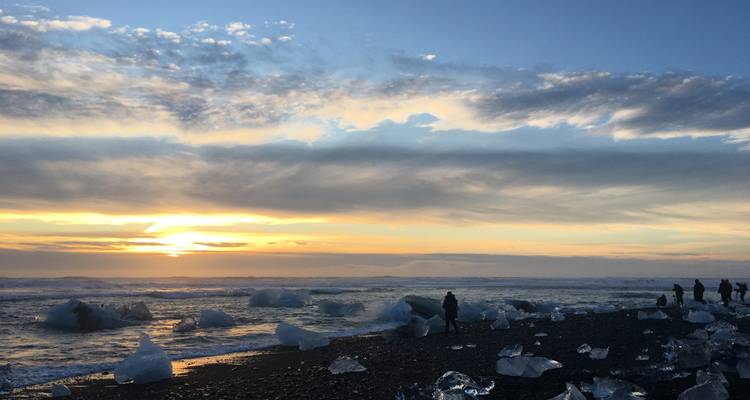 Aussicht auf Eisberge an einem Strand mit einem schönen Sonnenuntergang.