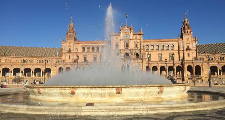 Fontaine devant la place d'Espagne avec un bâtiment historique en arrière-plan.