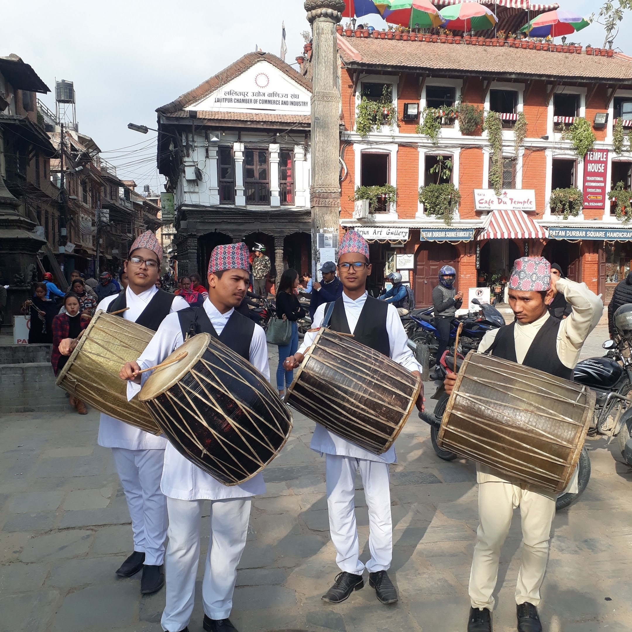 Musicians in traditional attire playing drums during a festival.