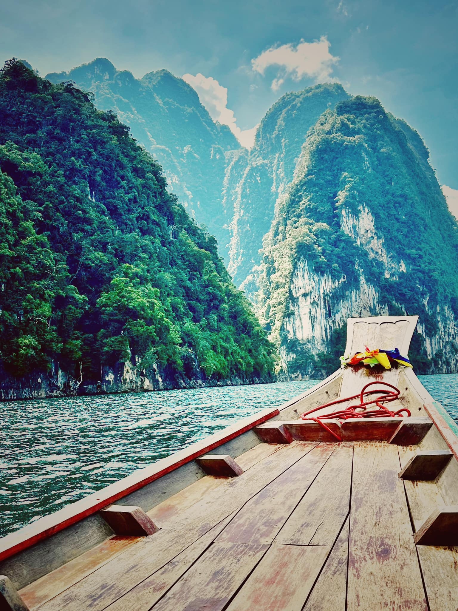 A boat on a river surrounded by lush cliffs.