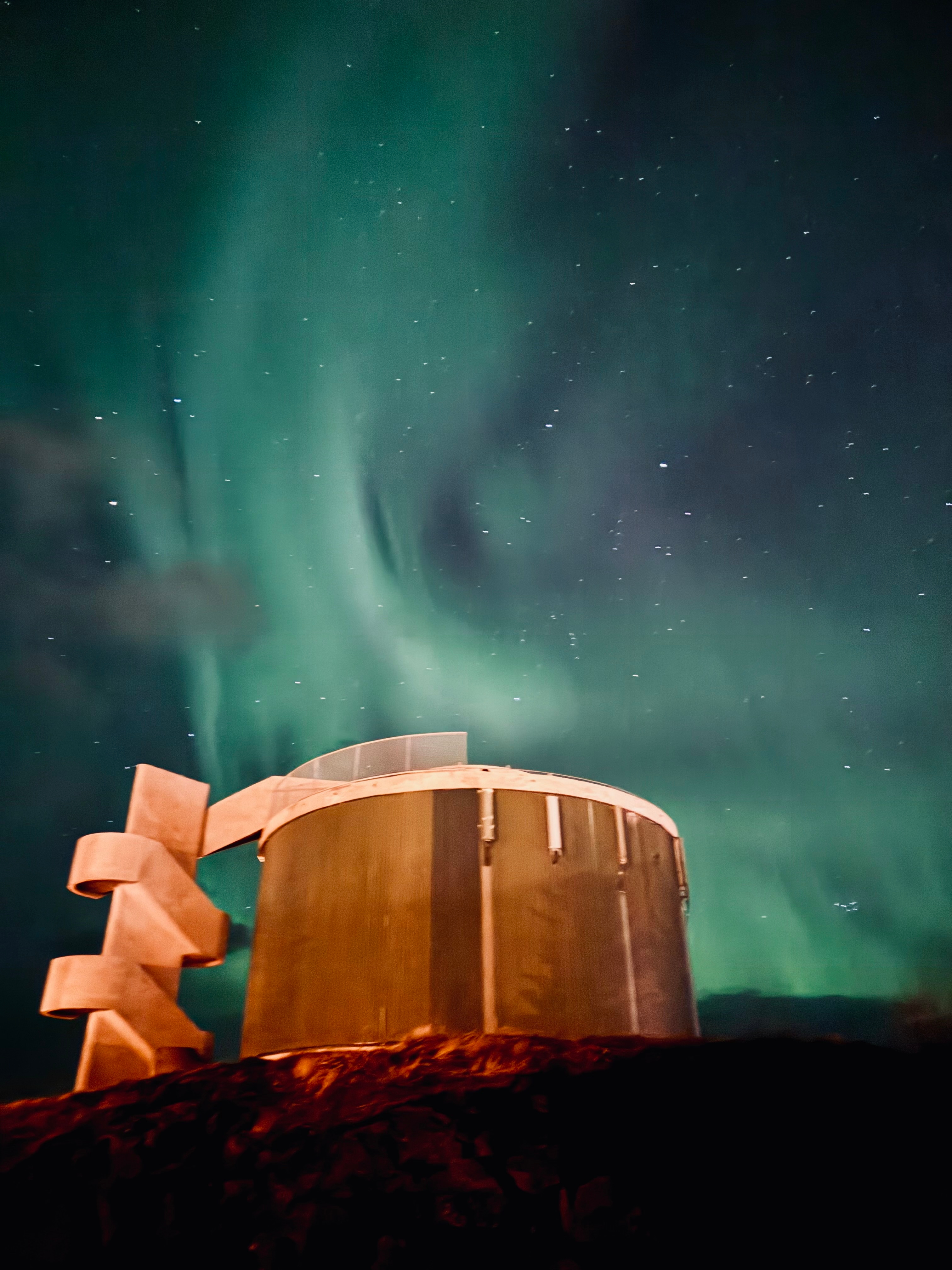 Northern lights over a futuristic building.
