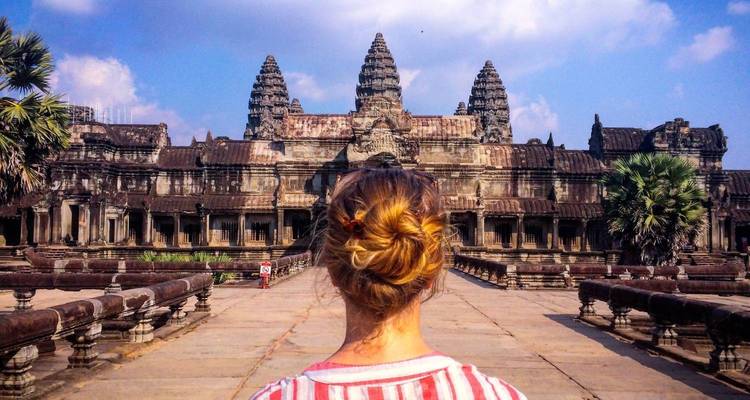 Una persona observando el templo de Angkor Wat desde atrás.