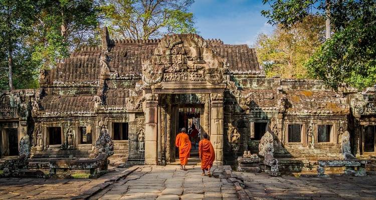 Monjes entrando a un templo antiguo intrincadamente tallado.