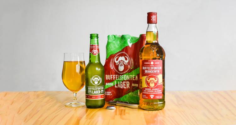 Bottles of South African lager and brandy on a table.