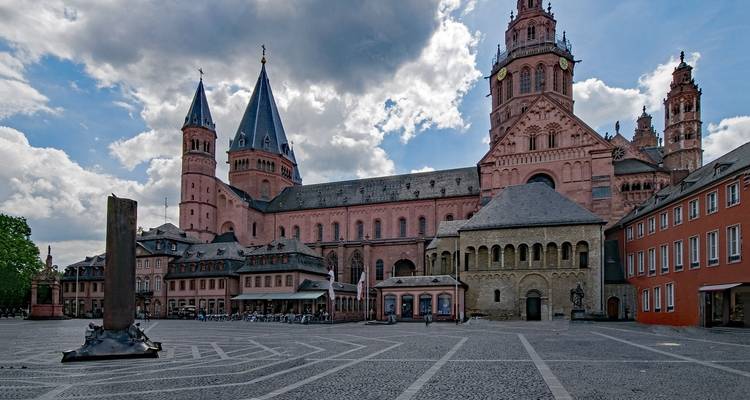 A large pink cathedral with blue spires under a partly cloudy sky.