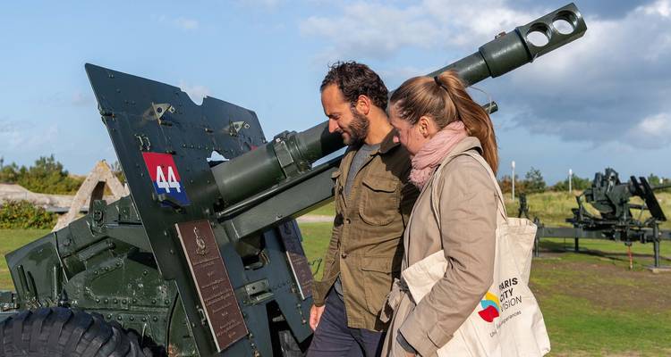 Deux personnes examinant une artillerie historique.