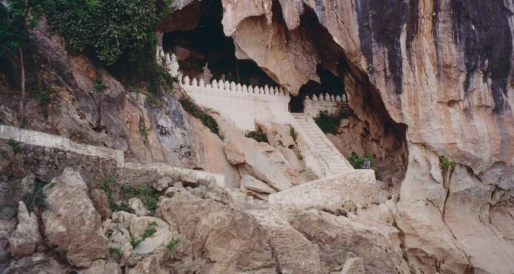 Stairs leading to a cave opening in a rocky hillside.