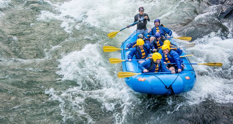 Grupo de personas practicando rafting en aguas bravas.