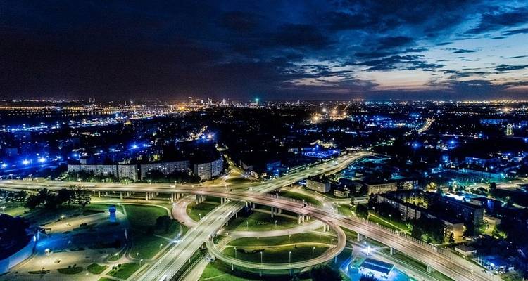 Night cityscape with illuminated roads and buildings.