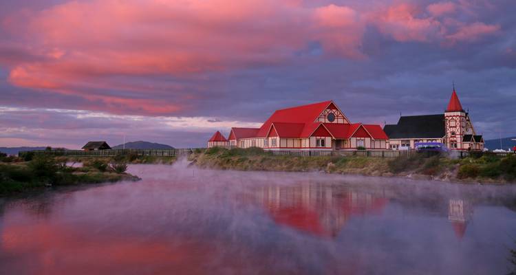 Colorful buildings reflected in a misty water scene.