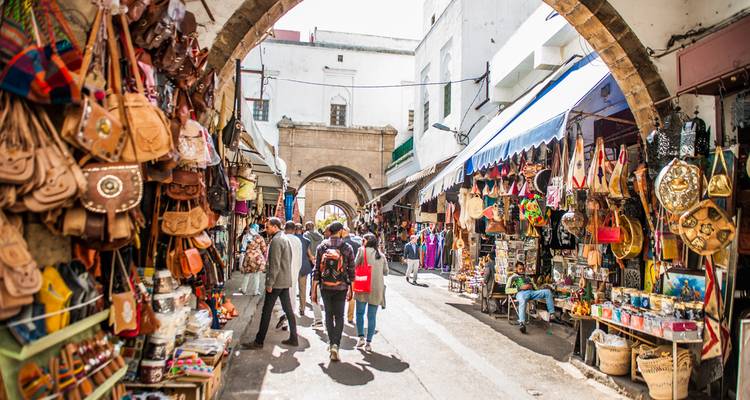 Belebte Marktstraße gesäumt mit bunten Lederwaren und Souvenirs
