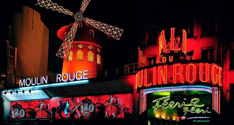 Les lumières néon brillantes du moulin du cabaret Moulin Rouge brillant contre le ciel nocturne.