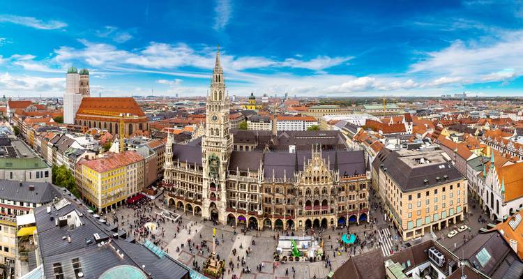 Vue aérienne panoramique de la Marienplatz de Munich avec l'ornée Nouvelle Mairie et la Frauenkirche aux tours jumelles s'élevant au-dessus de foules animées.