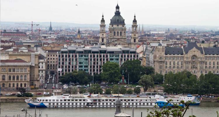 Vista panorámica sobre el río Danubio hacia la Basílica de San Esteban y el centro de Budapest con un crucero fluvial en primer plano.