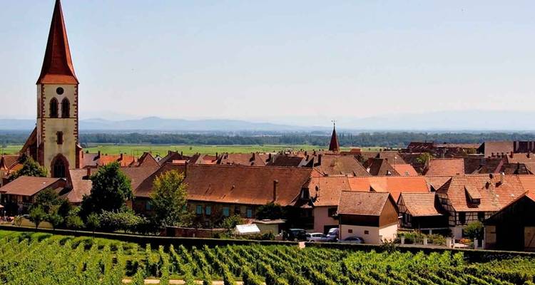 Village français rural aux toits de tuiles rouges niché parmi de vastes vignobles