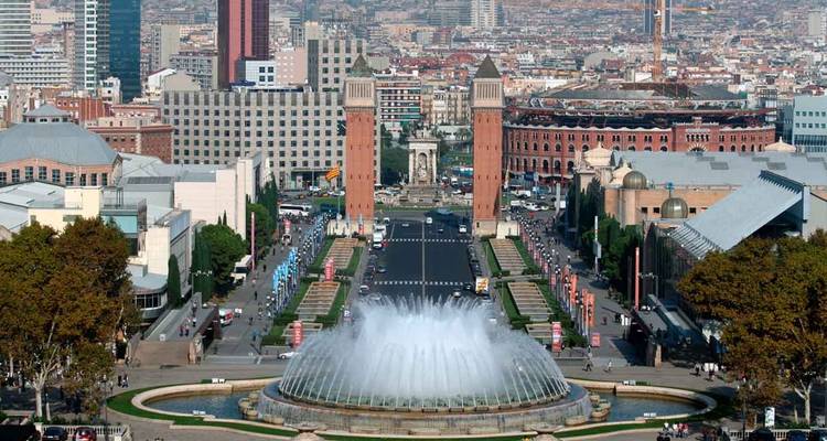 Vista aérea de la Plaça d'Espanya de Barcelona con las torres venecianas gemelas y la Fuente Mágica en primer plano.