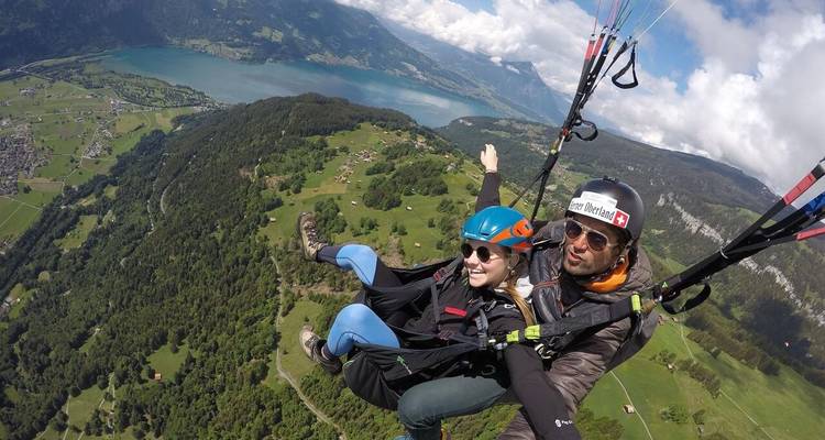Deux personnes faisant du parapente au-dessus d'un lac.