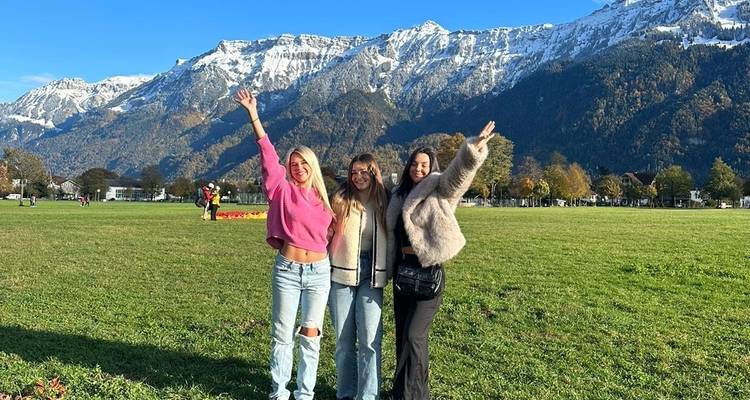 Drei Personen posieren vor einer Berglandschaft.