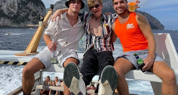 Trois jeunes hommes heureux sur un bateau avec un arrière-plan océanique.