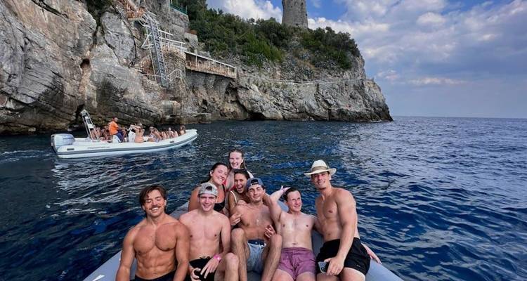 Groupe de personnes sur un bateau près de falaises rocheuses.