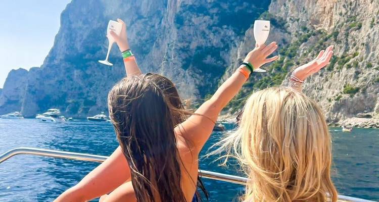 Deux femmes sur un bateau levant des coupes de champagne.