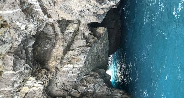 Vue rapprochée de falaises rocheuses avec une eau turquoise.