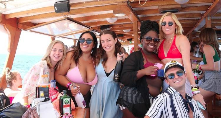 Groupe de personnes sur un bateau profitant d'une fête avec des boissons.
