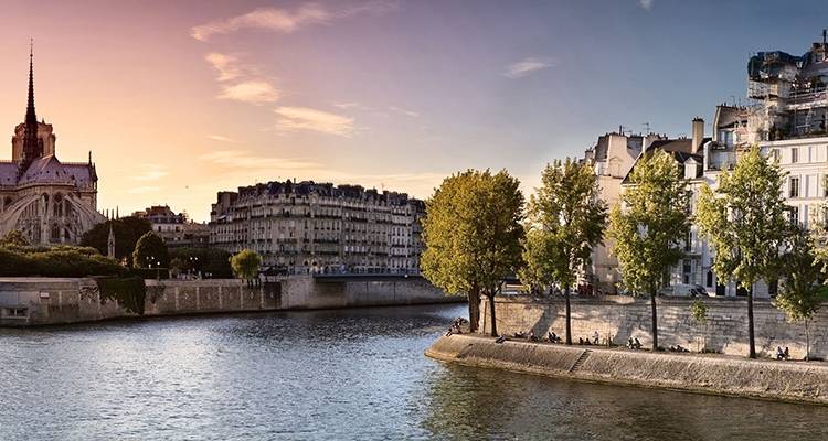 De Seine rivier tijdens het gouden uur met de Notre-Dame kathedraal en elegante riviergebouwen.