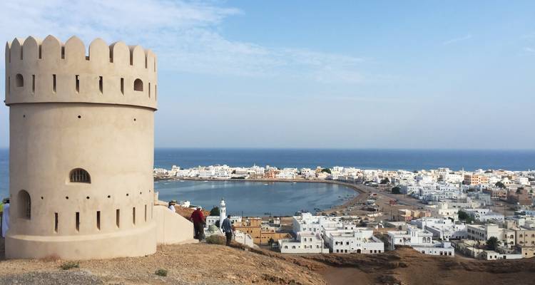 Una torre de vigilancia costera redonda se asoma al pueblo blanqueado de Sur y al reluciente Mar Arábigo.