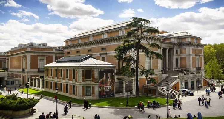 Large museum building with people and trees around.