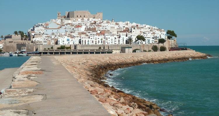 Seaside fortress with white houses and a breakwater.