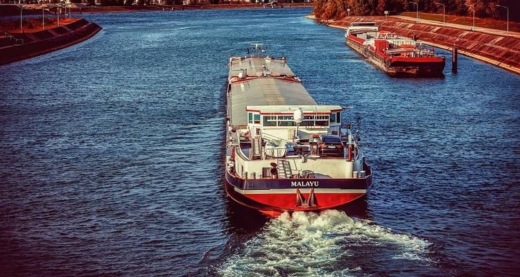 Large cargo ships navigating through a river.