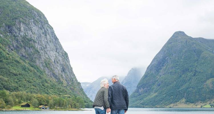 Couple walking in a dramatic fjord landscape.