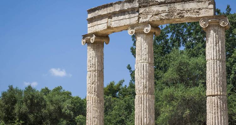 Columnas griegas antiguas en medio de un paisaje de vegetación