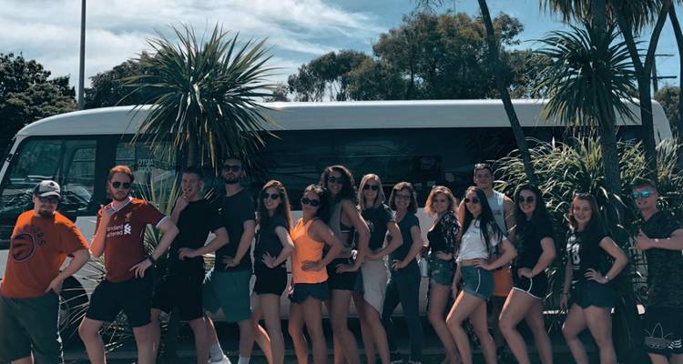 Groupe posant devant un autobus entouré d'arbres.