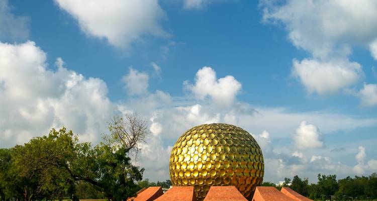 Eine große goldene Kugelstruktur inmitten von Grün.