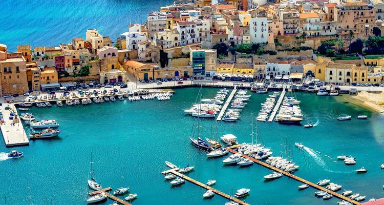Impresionante vista aérea de la marina de Castellammare del Golfo rodeada de coloridos edificios históricos a orillas del agua.
