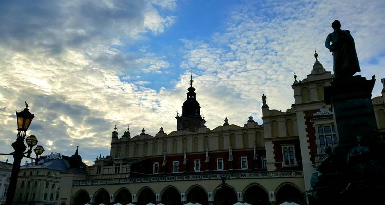 Silhouetted Cloth Hall facade and tower in Krakow against a dramatic early evening sky