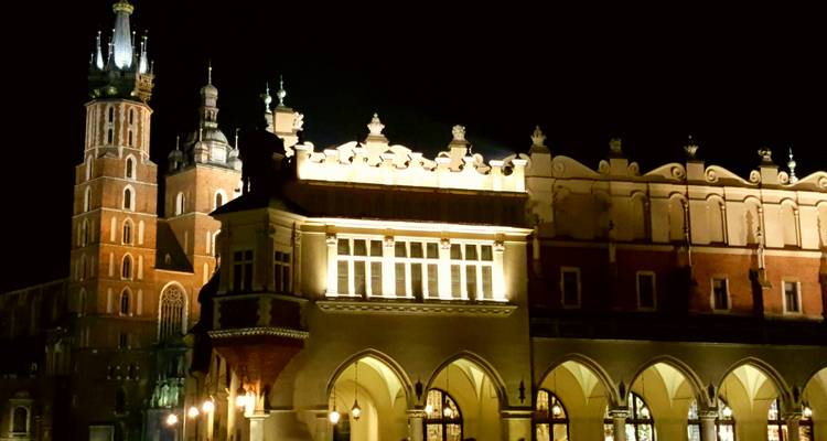 Illuminated St. Mary's Basilica and Cloth Hall at night in Krakow's main square