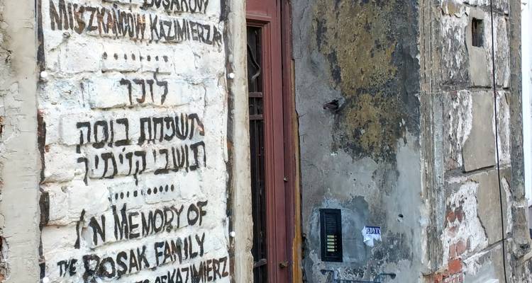Aged brick wall featuring memorial text in Hebrew and Polish in Krakow's Kazimierz district