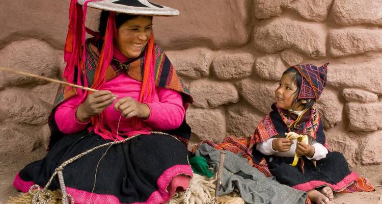 Vrouwen in traditionele Peruaanse kleding bezig met handwerk.