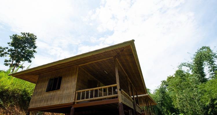 Bungaló de bambú en un entorno tropical.
