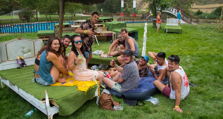 Groupe de personnes se détendant à l'extérieur sur une structure semblable à un lit.