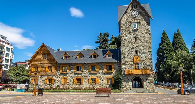 Ein historisches Steingebäude mit einem Uhrenturm auf einem öffentlichen Platz.