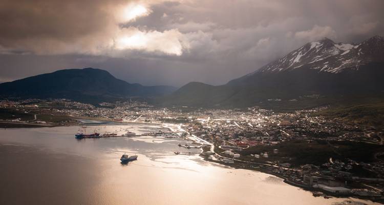 Luchtfoto van de haven van Ushuaia met besneeuwde bergen op de achtergrond.
